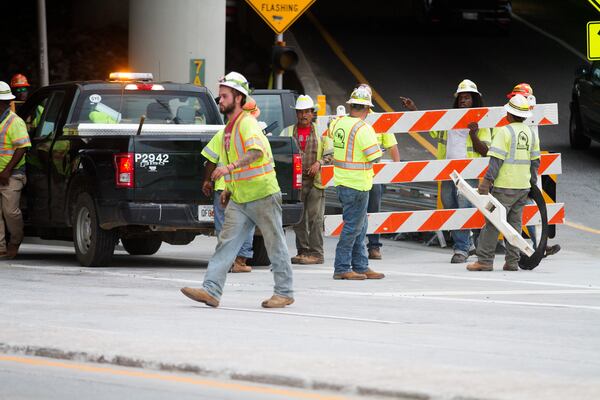 Workers clear away roadblocks on Piedmont road after opening northbound lanes of I-85 in Atlanta GA. Friday evening, May 12, 2017. STEVE SCHAEFER / SPECIAL TO THE AJC