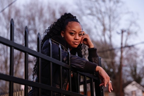 malia dishon, daughter of  Organized Noize co-founder Ray Murray,  poses for a portrait in front of The Dungeon Family home in Atlanta on Monday, Feb. 17, 2025. Natrice Miller/ AJC)
