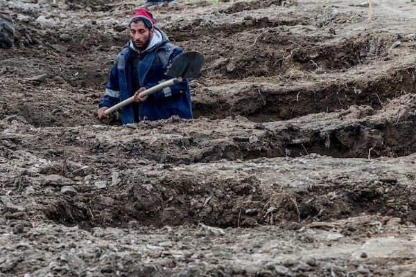 A worker digs graves for the victims of a massive nightclub fire in the town of Kocani, North Macedonia, Tuesday, March 18, 2025. (AP Photo/Visar Kryeziu)