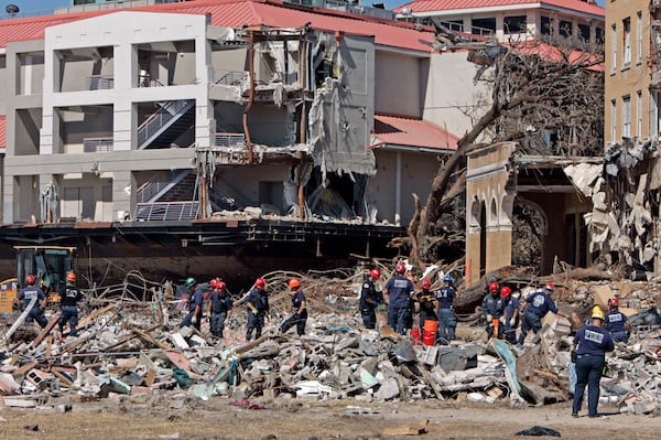 FILE - Firefighters from the Los Angeles Fire Department search through the rubble of buildings damaged by Hurricane Katrina along the coastline in East Biloxi, Miss., Sept. 7, 2005. (AP Photo/Darron Cumming, File)