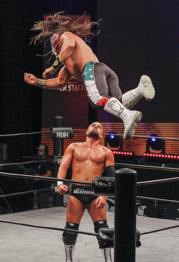 The masked Ring of Honor wrestler Bandido flies down onto Marty Scurll. They fought during a show by wrestling promotion Ring of Honor on Saturday, Aug. 24, 2019 at Center Stage Theater in Atlanta. (Ben Brasch/AJC)