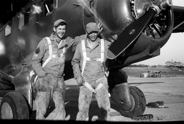 Sgt. Jim Galloway, left,  in grease-stained coveralls and a parachute.