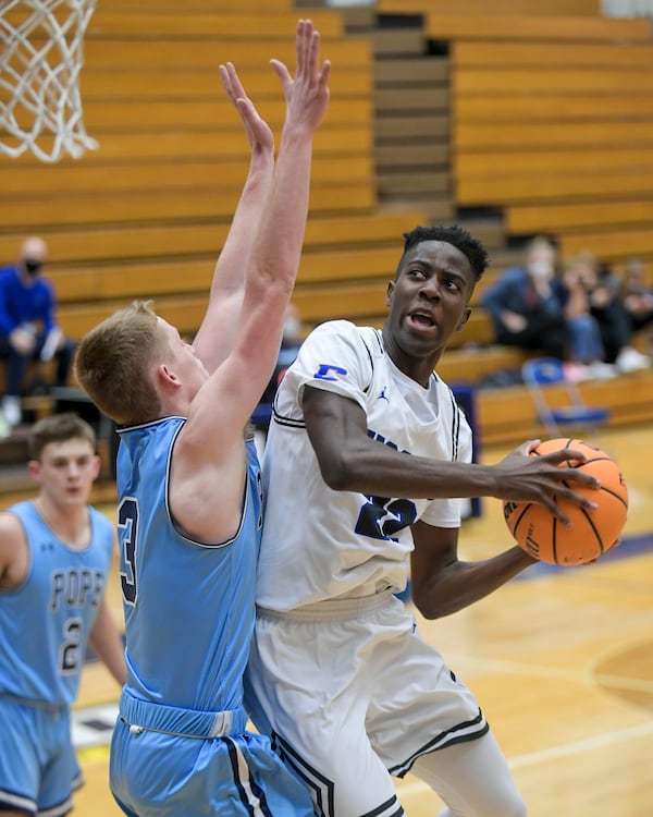 Chattahoochee’s Gil Matondo (22) drives to the basket as Pope’s Will Kuimjian (3) blocks during their Class 6A first round tournament game at Chattahoochee High School Wednesday, February 24, 2021. (Daniel Varnado/For the AJC)