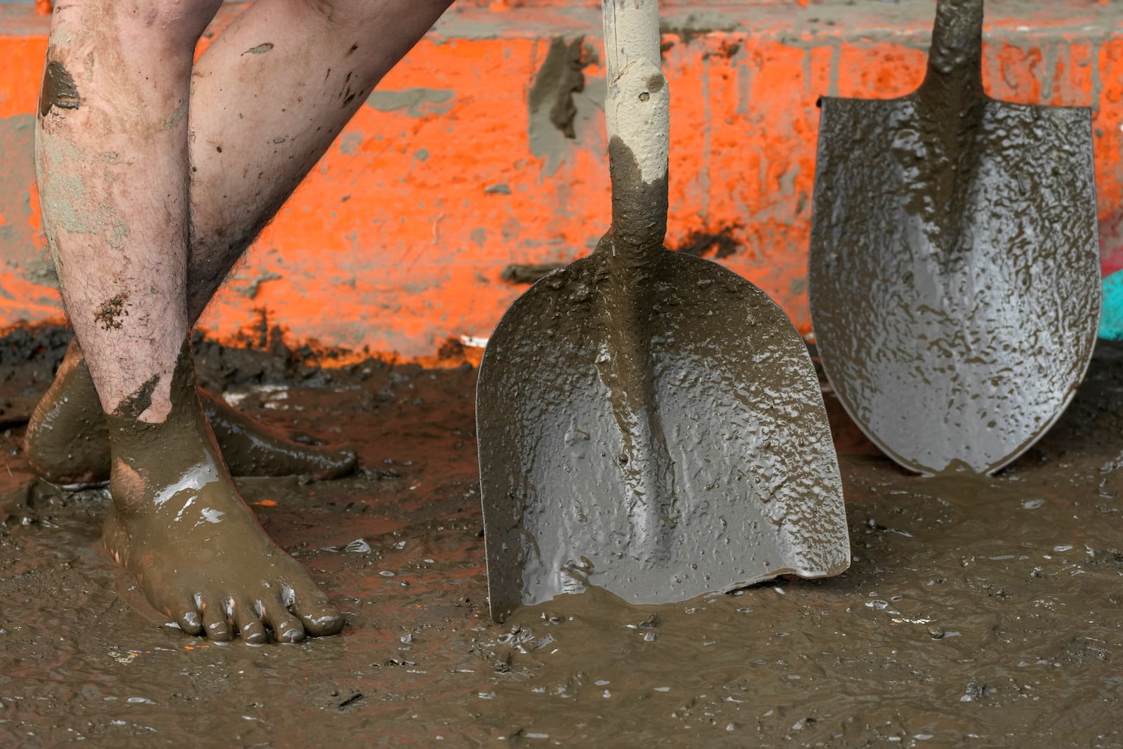 A resident uses shovels as they clean out mud from their house after a landslide triggered by Tropical Storm Trami struck homes in Talisay, Batangas province, Philippines on Saturday, Oct. 26, 2024. (AP Photo/Aaron Favila)