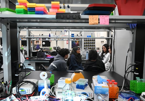 Students in Lambert High School's IGEM program, including Sahasra Tatavarti (second from left), discuss their project on Thursday, Dec. 12, 2024. (Hyosub Shin/AJC)