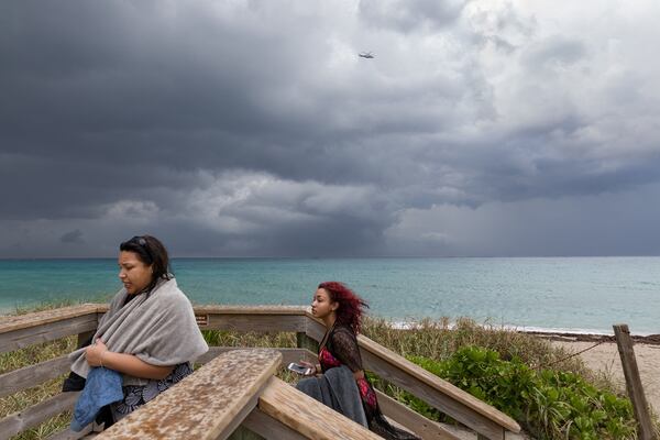 People flee the beach as rain starts to fall in Palm Beach, Florida, April 24, 2018. (Greg Lovett / The Palm Beach Post)