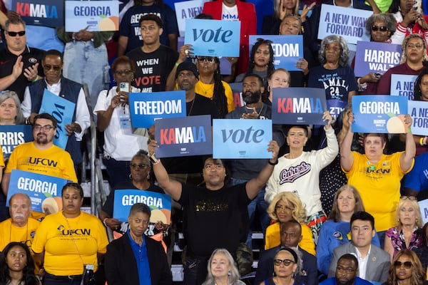 Supporters hold up signs during a campaign rally with Vice President Kamala Harris in Clarkston on Thursday.