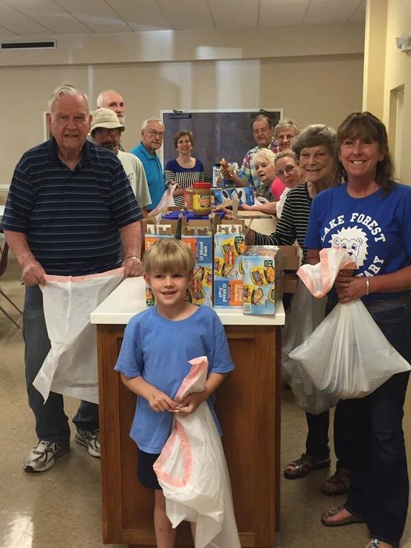 Sandy Springs United Methodist Church members gather each Wednesday to pack food for weekend meals for kids. Bruce Donnelly (right rear in madras plaid shirt), director of the program, and a regular group of volunteers put enough food in the sacks to provide a meal for the child’s family as well as breakfast, lunch and dinner for a child throughout the weekend. CONTRIBUTED BY LARA FERGUSON