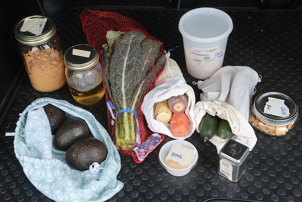 Sonya Shah’s recent shopping trip at the Sevananda Natural Foods Market reflects her zero waste lifestyle: All the containers and bags are reusable for her items that include organic peanut butter in a reused spaghetti sauce jar, hand soap, avocados in a cloth shirt made into a bag, kale, garlic powder, carrots, a can of oregano, black-eyed peas, cucumbers, and rice crackers. CURTIS COMPTON / CCOMPTON@AJC.COM