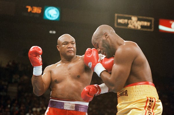 FILE - George Foreman, left, hits Michael Moorer in the face with a left during the second round of their heavyweight championship fight at the MGM Grand in Las Vegas on Saturday, Nov. 5, 1994. (AP Photo/Lennox McLendon, File)