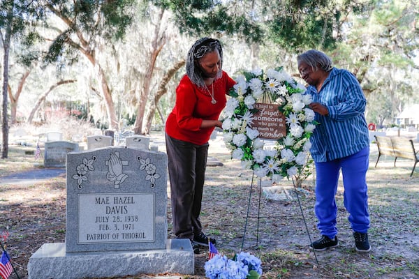 Jannie Everette, CEO/President of the Thiokol Memorial Project, and Emma Lou Gibbs reposition a wreath at the grave of Mae Hazel Davis, one of the victims of the 1971 explosion at Thiokol.