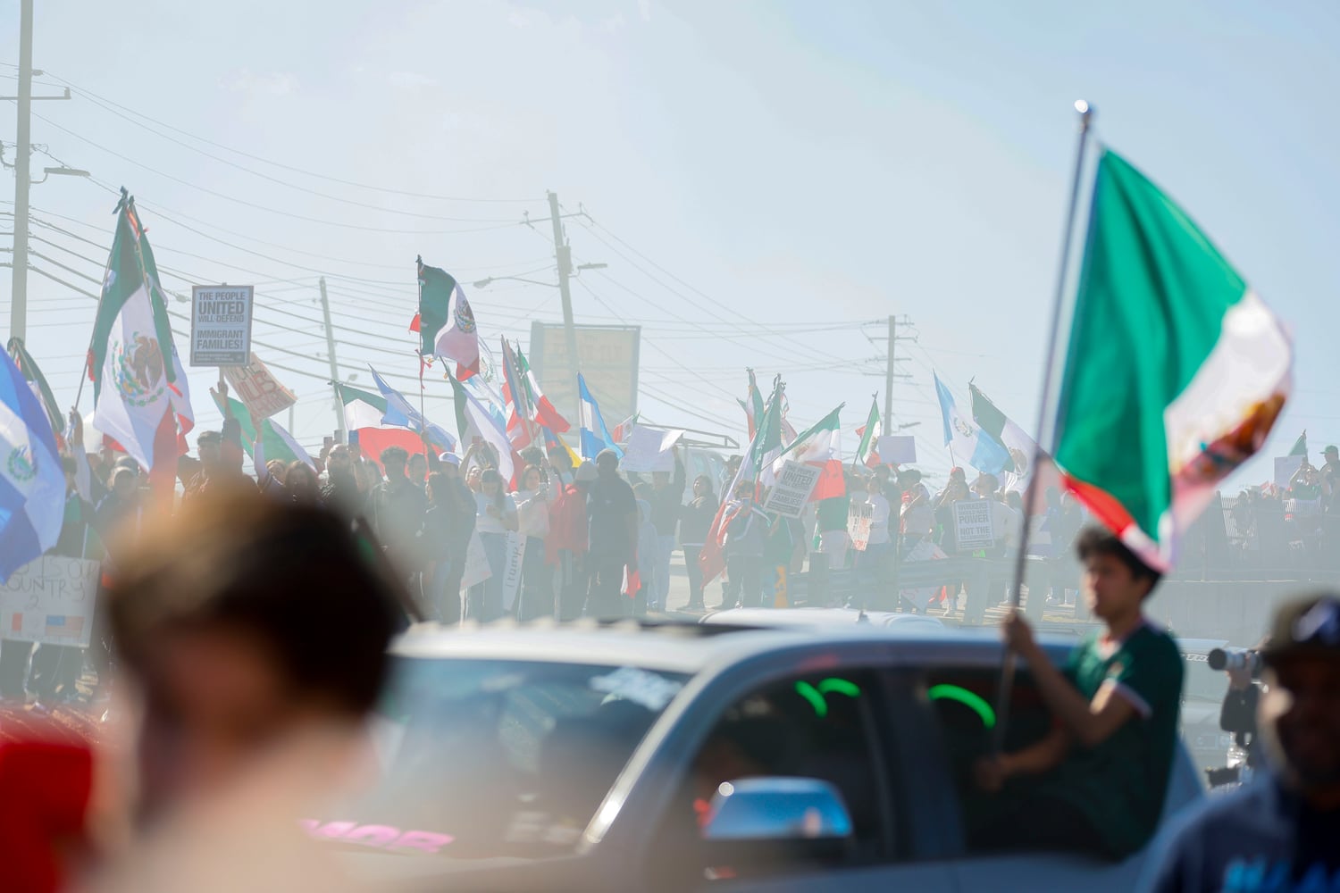 Pro-immigrant protesters gathered on Buford Highway as they waved Latin-American flags surrounded by smoke near Plaza Fiesta on Saturday, Feb. 1, 2025, to demonstrate in response to a recent immigration arrest in Georgia. 
(Miguel Martinez/ AJC)