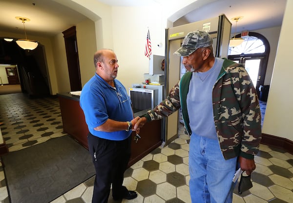 Former Putnam County High School principal Jacob Bennekin, right, thanks Deputy Sgt. John Harper for his 31 years of police service at the Putnam County Courthouse in Eatonton, where Harper leads courthouse security. (Curtis Compton / Curtis.Compton@ajc.com)