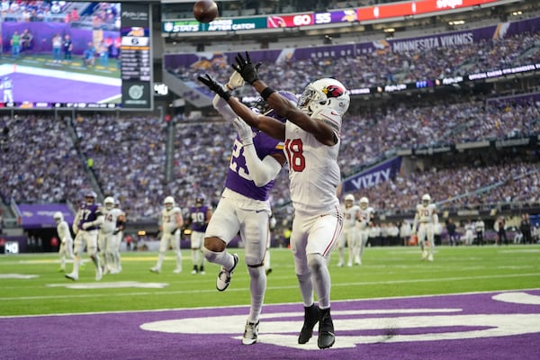 Arizona Cardinals wide receiver Marvin Harrison Jr. (18) catches a 15-yard touchdown pass over Minnesota Vikings cornerback Fabian Moreau (23) during the second half of an NFL football game Sunday, Dec. 1, 2024, in Minneapolis. (AP Photo/Abbie Parr)