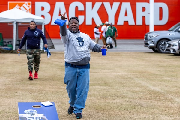 Howard University Bison fan Brian Warrel plays a game of Cornhole at The Home Depot Backyard near the Mercedes-Benz Stadium before the start of the Celebration Bowl Saturday, Dec. 16, 2023.  (Steve Schaefer/steve.schaefer@ajc.com)