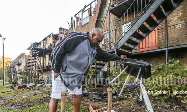 Rodney Blalock, a resident of the building, rummages through the remains of the overnight fire.