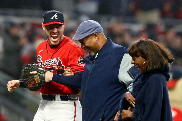 Atlanta Braves first baseman Freddie Freeman (left) reacts after Hank Aaron Jr. threw out the ceremonial first pitch before the start of game 3 between the Atlanta Braves and the Houston Astros during the World Series at Truist Park, Friday October 29, 2021, in Atlanta. (Photo: Curtis Compton / curtis.compton@ajc.com )