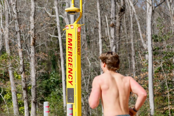 A jogger exercises at the intramural fields as he passes an emergency call station on the east side of the UGA campus on Tuesday, February 18, 2025. One year after the murder of Laken Riley, the University of Georgia has allocated millions of dollars toward safety enhancements; however, some students continue to express safety concerns.
(Miguel Martinez/ AJC)