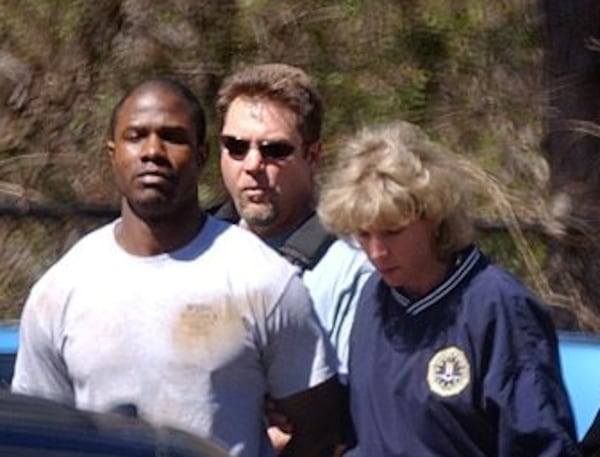 FBI and other local and national law enforcement agencies escort Brian Nichols to a waiting van after booking him at Atlanta's FBI headquarters on Saturday, March 12, 2005. W.A. BRIDGES JR./AJC FILE