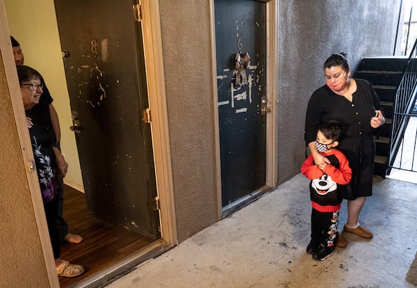 201218-Atlanta-Myrtle Goodman, left, and her son Walter talk with neighbors Gabiela Duran her son Derek Duran, 4 outside of their Buford Highway apartment. Goodman has lived in her apartment for more than 20 years and says the complex management hasnÕt repaired many of the issues she has brought to their attention. She said her front door was last paint 10 years ago.  Ben Gray for the Atlanta Journal-Constitution