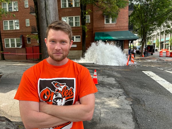 Midtown resident Stan Reecy is seen in front of a water main break at the corner of 11th Street and West Peachtree Street on Sunday. 