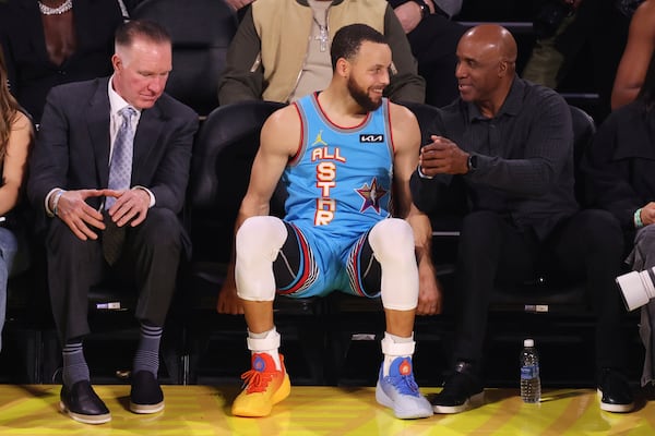 Golden State Warriors guard Stephen Curry sits with Chris Mullin, left, and Barry Bonds during the NBA All-Star basketball game Sunday, Feb. 16, 2025, in San Francisco. (AP Photo/Jed Jacobsohn)