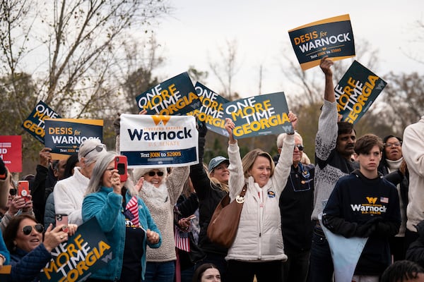 Supporters of  U.S. Sen. Raphael Warnock (D-Ga.) hold signs during his campaign stop in Cumming, Ga., on Nov. 19, 2022. Warnock won his reelection bid on Tuesday. (Nicole Craine/The New York Times)