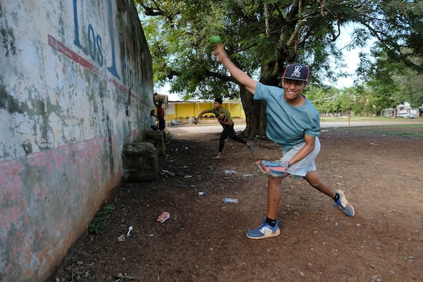 Teenage baseball players practice pitching during their daily training at the Trinitarios ballpark in Santo Domingo, Dominican Republic, Wednesday, Feb. 5, 2025. (AP Photo/Ricardo Hernandez)