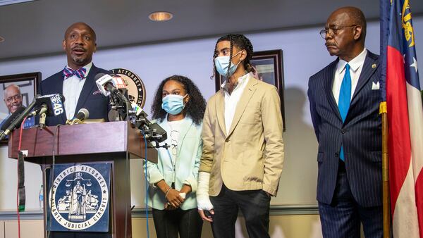 Attorney Mawuli Mel Davis (left) speaks on behalf of Taniyah Pilgrim (second from left) and Messiah Young (second from right) during a press conference by the Fulton County District Attorney's Office in Atlanta, Monday, June 2, 2020. District Attorney Paul Howard (right) announced criminal charges against six Atlanta police officers involved the arrest of Pilgrim and Young.  Davis is representing  Young.