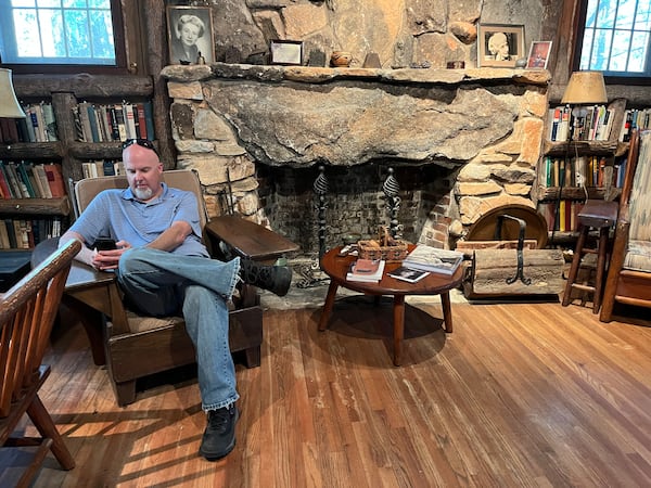 Matthew Teutsch, director of the Lillian E. Smith Center at Piedmont University, checks his email in Smith's former cottage,  where the bookshelves are filled with volumes by Freud, Schopenhauer, Spinoza and Kant. Photo: Bo Emerson