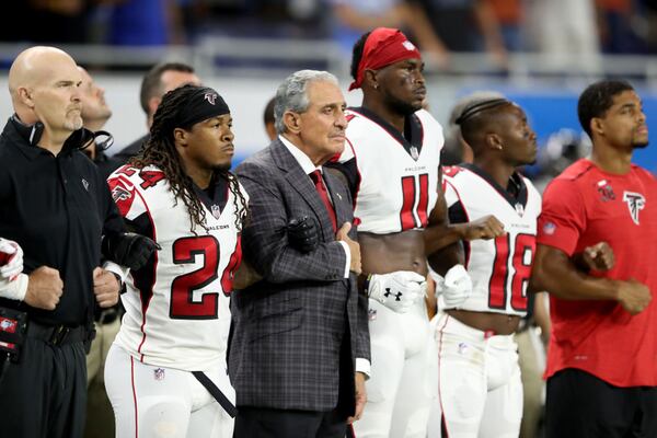 Atlanta Falcons owner Arthur Blank joins arms with his players during the national anthem prior to the game against the Detroit Lions at Ford Field on September 24, 2017 in Detroit, Michigan.