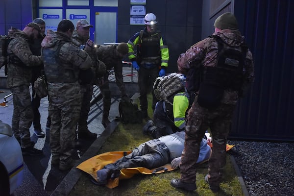 A paramedic examines a body of a killed person after Russian missile hit a private medical clinic in Zaporizhzhia, Ukraine, Tuesday, Dec. 10, 2024. (AP Photo/Andriy Andriyenko)