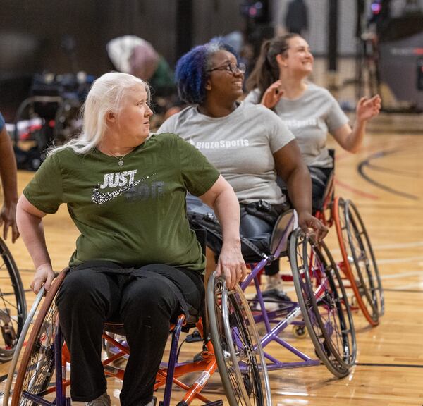 The Lady Ballers wheelchair team members Carrie Willoughby (from left), Patria Brown and Lexi Sklar listen to instructions during practice at Shoot 360 in Alpharetta.  PHIL SKINNER FOR THE ATLANTA JOURNAL-CONSTITUTION