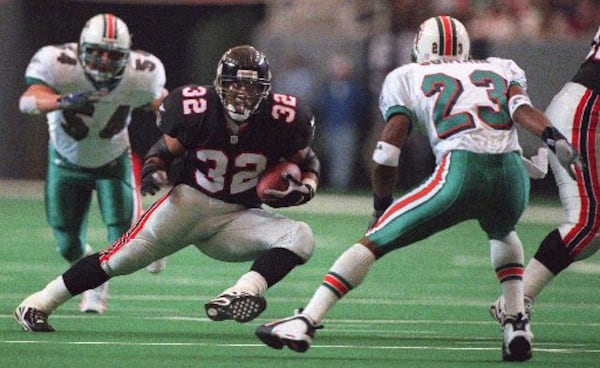 981227-ATLANTA-Falcons' Running back Jamal Anderson (cq) cuts to the side while trying to fake out the Dolphins' Patrick Surtain (cq) as Zach Thomas (cq) closes from behind during the second quarter of Sunday's (12/27/98) game in Atlanta. The Falcons won the final regular-season game 38-16. (BEN GRAY/STAFF)