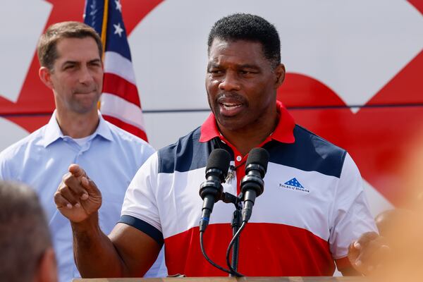 Republican U.S. Senate hopeful Herschel Walker speaks at his “United Georgia” campaign bus tour in Carrollton on Oct. 11, 2022 as Arkansas Sen. Tom Cotton stands behind him in support.  (Arvin Temkar / arvin.temkar@ajc.com)