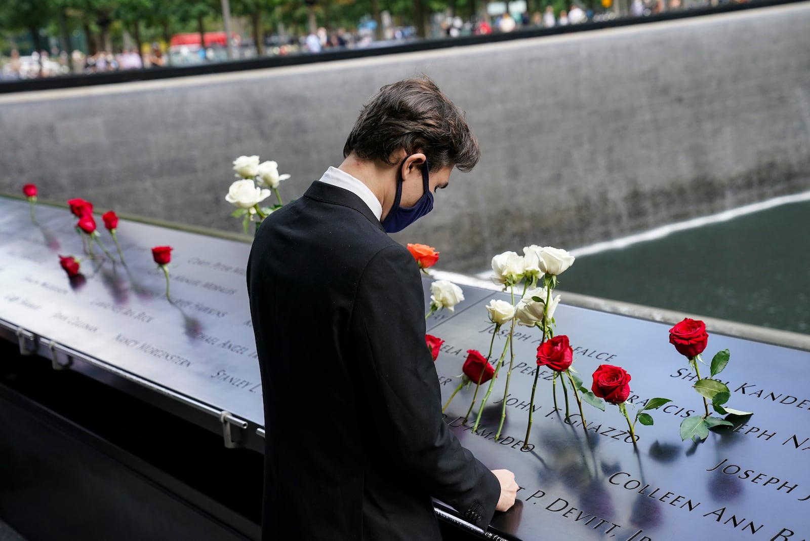  The Sept. 11, 2001, terrorist attacks and the war on terror that followed claimed the lives of more than 225 Georgians.  Pictured is a mourning pausing at the north reflecting pool as flowers are placed in the names of the dead at the National September 11 Memorial and Museum on Sept. 11, 2020, in New York. (John Minchillo/AP)