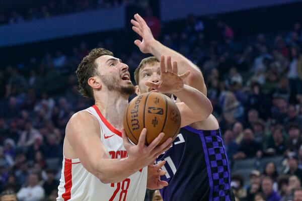 Houston Rockets center Alperen Sengun, left, drives past Sacramento Kings forward Domantas Sabonis during the first half of an Emirates NBA Cup basketball game in Sacramento, Calif., Tuesday, Dec. 3, 2024. (AP Photo/Randall Benton)