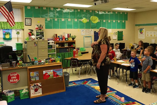 R.M. Moore Elementary School teacher Christina Ortiz leads her first-graders in the Pledge of Allegiance on Monday, the first day of class for the 2016-17 school year. 