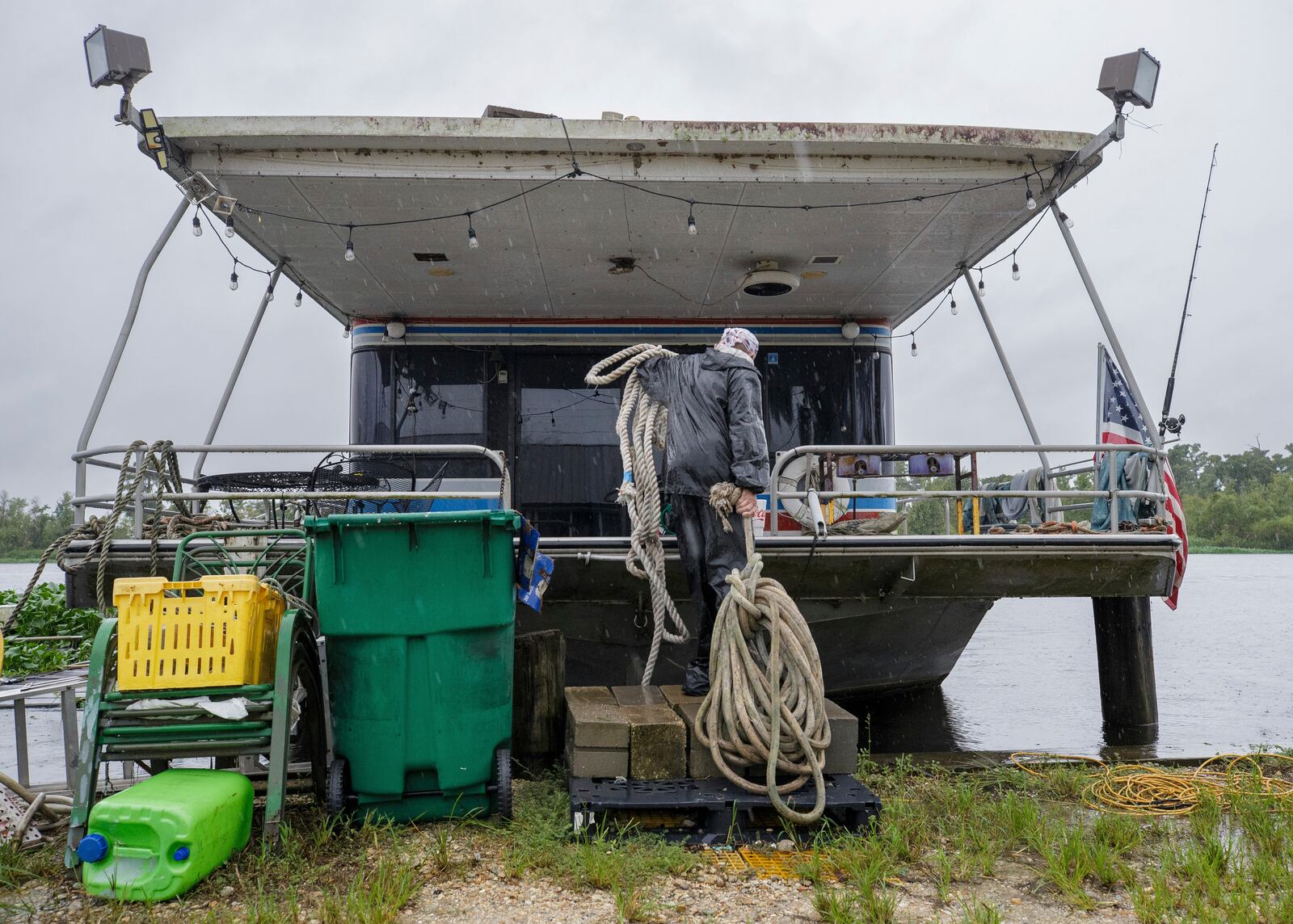 Jason Bledsoe hauls rope to a houseboat in preparation of moving it to a safer dock, Wednesday, Sept. 11, 2024, in Bayou Gauche, La., ahead of Hurricane Francine. (David Grunfeld/The Times-Picayune/The New Orleans Advocate via AP)