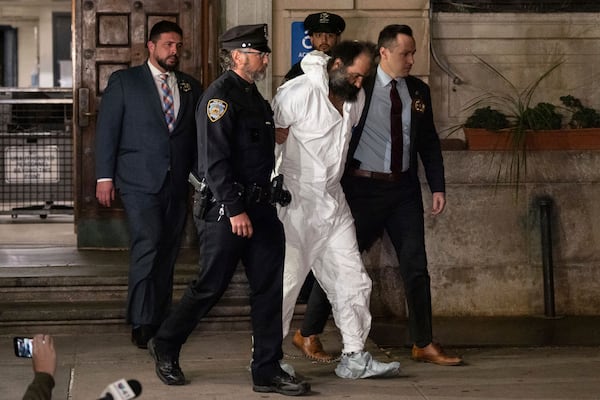 Ramon Rivera, a suspect arrested after multiple people were stabbed early Monday, is escorted out by NYPD officers at the NYPD 10th Precinct in New York, Monday, Nov. 18, 2024. (AP Photo/Yuki Iwamura)