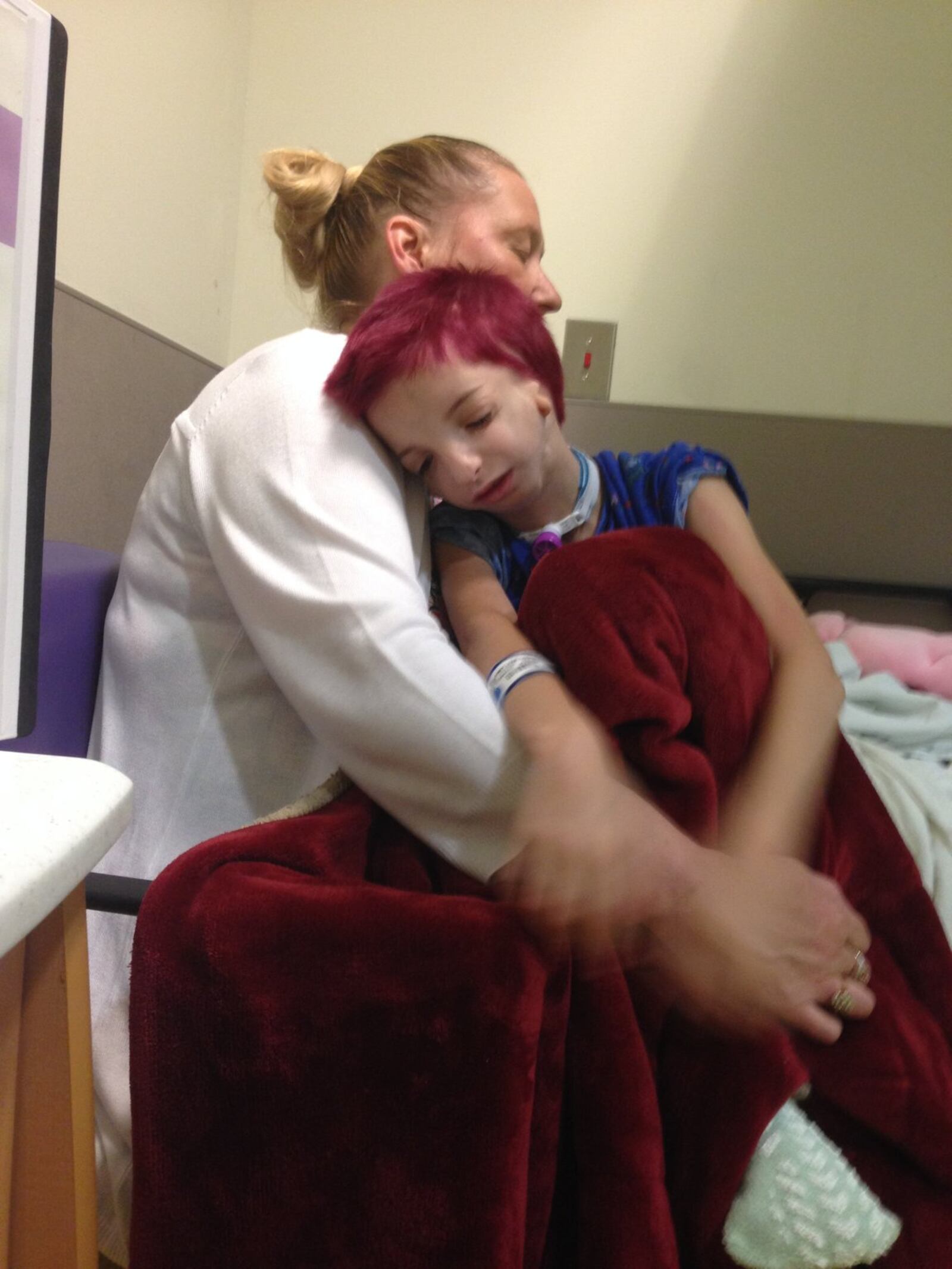 Lexie, who has Treacher Collins syndrome, relaxes with her mom, Amy Delaney, before undergoing her 30th surgery recently at Children’s Healthcare of Atlanta. She is one of six children Amy and her husband adopted who have some type of physical or developmental disability. GRACIE BONDS STAPLES / GSTAPLES@AJC.COM