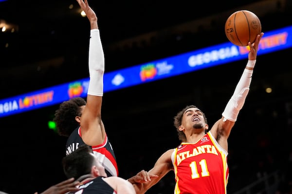 Atlanta Hawks guard Trae Young (11) scores as Portland Trail Blazers' Matisse Thybulle, left, defends during the first half of an NBA basketball game Friday, March 3, 2023, in Atlanta. (AP Photo/John Bazemore)