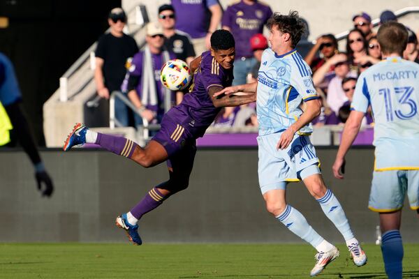 Orlando City's Wilder Cartagena, left, tries to get possession of the ball in front of Atlanta United's Aleksey Miranchuk (59) during the first half of an MLS Semifinal Conference playoff soccer match, Sunday, Nov. 24, 2024, in Orlando, Fla. (AP Photo/John Raoux)