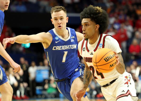 Louisville's Chucky Hepburn, right, drives past Creighton's Steven Ashworth (1) during the first half in the first round of the NCAA college basketball tournament in Lexington, Ky., Thursday, March 20, 2022. (AP Photo/James Crisp)