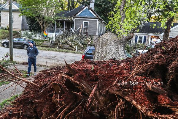 An uprooted tree in a neighbor’s yard fell across McPherson Avenue and onto a home in southeast Atlanta after fast-moving storms swept through the city at midday Tuesday. 