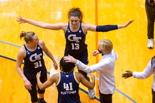 Georgia Tech guard Lotta-Maj Lahtinen (31), forward Lorela Cubaj (13), guard Kierra Fletcher (41) and coach Nell Fortner celebrate the team's 73-56 win over West Virginia in a college basketball game during the second round of the NCAA women's tournament at the UTSA Convocation Center in San Antonio on Tuesday, March 23, 2021. (AP Photo/Stephen Spillman)