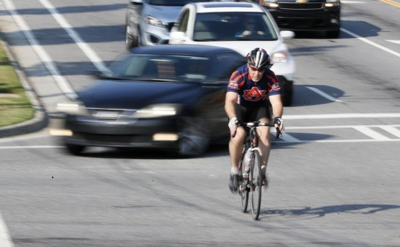 A cyclist crosses the Mt. Vernon and Chamblee Dunwoody Road intersection in Dunwoody. (Bob Andres / robert.andres@ajc.com)