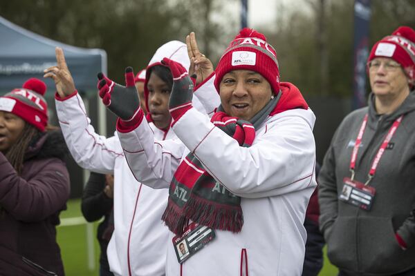 Iris Hawkins (center) and other volunteers with the Atlanta Super Bowl Host Committee cheer during an urban forest project event at the Salvation Army Bellwood Boys and Girls Club in Atlanta’s English Avenue community on Tuesday. (ALYSSA POINTER / ALYSSA.POINTER@AJC.COM)