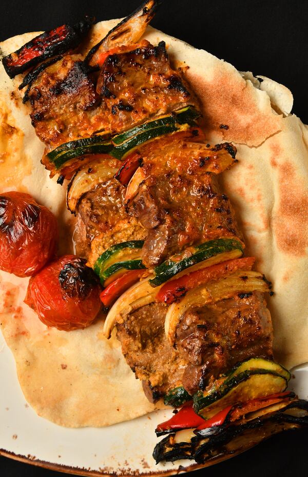 Beef Shish Kebabs, with onions, zucchini and red pepper. The kebabs are accompanied with grilled Roma tomatoes. (Styling by Peter Teimori / Chris Hunt for the AJC)