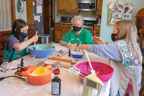 Aubree White (left) and Bryn Hammock (right) join their grandmother, Deanna Simmons, to make cookies from a 1922 Girl Scout recipe. Courtesy of Kathryn White